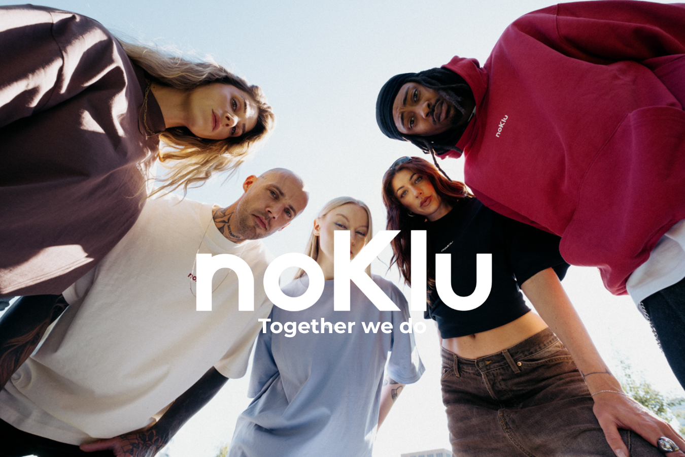 Five young adults looking down at the camera in a circle outdoors under a bright sky, with the white text 'noKlu' and 'Together we do' overlaid across the center.
