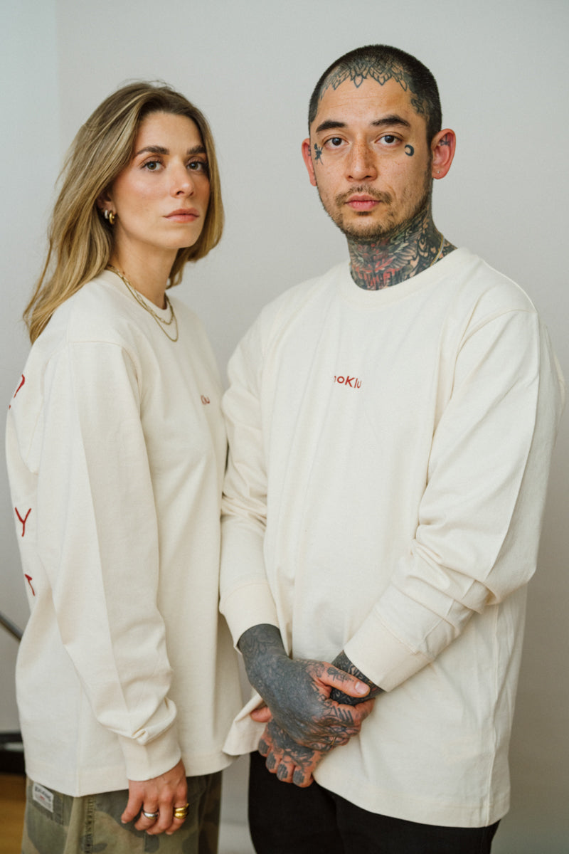 Two people with a light beige long sleeve shirt looking in the camera