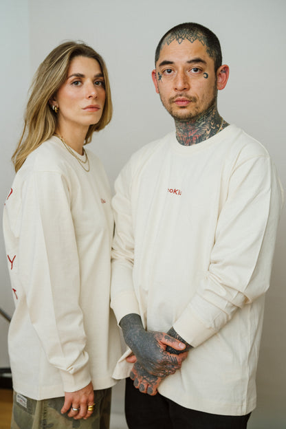 Two people with a light beige long sleeve shirt looking in the camera