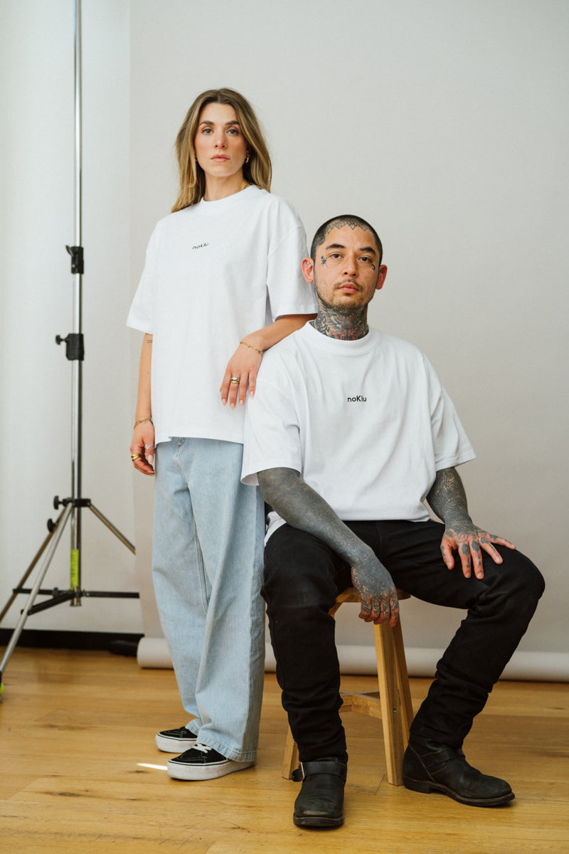 Two people wearing white t-shirts in a studio setting.