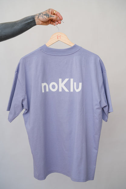 Purple t-shirt with 'noKlu' logo on a hanger against a gray background